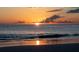 Golden sunset over the ocean, with a reflection of the sun on the wet sand at 7701 Palm Dr, Holmes Beach, FL 34217