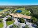Stunning aerial view of a golf community featuring a clubhouse and green courses surrounded by lush landscaping at 8211 Summer Greens Ter, Bradenton, FL 34212