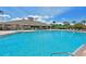 Stunning community pool and clubhouse featuring a sparkling pool with lounge chairs and a shady pergola at 8211 Summer Greens Ter, Bradenton, FL 34212