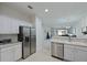 Bright kitchen with stainless steel appliances and white cabinets, open to living area at 8211 Summer Greens Ter, Bradenton, FL 34212