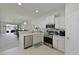 Open kitchen with stainless steel appliances, white cabinetry, and a view into the adjacent living area at 8211 Summer Greens Ter, Bradenton, FL 34212