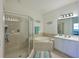 Main bathroom featuring a glass-enclosed shower, separate soaking tub, and a vanity with sink at 8211 Summer Greens Ter, Bradenton, FL 34212