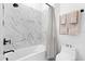 Modern bathroom features marble-tiled walls, sleek fixtures, and a relaxing bathtub at 8227 Nevis Run, Bradenton, FL 34202