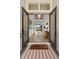 Charming entryway featuring 'COME IN' welcome mat, modern chandelier, and hallway view at 8227 Nevis Run, Bradenton, FL 34202