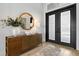 Elegant foyer with hardwood floors, a modern console table, and a black framed door at 8227 Nevis Run, Bradenton, FL 34202