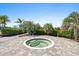Inviting hot tub surrounded by lush palm trees and beautiful landscaping, creating a private oasis at 8227 Nevis Run, Bradenton, FL 34202
