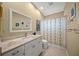 Well-lit bathroom with decorative mirror, a neutral shower curtain, and marble countertop at 8328 Barton Farms Blvd, Sarasota, FL 34240