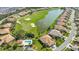 Aerial view showcasing the community's golf course, serene lake, and beautiful homes with pools at 9411 Forest Hills Cir, Sarasota, FL 34238