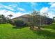 Expansive backyard with lush greenery, a screened-in patio, and mature trees offering privacy at 9411 Forest Hills Cir, Sarasota, FL 34238