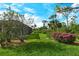 Expansive backyard featuring lush green lawn, mature landscaping, and screened-in lanai for outdoor enjoyment at 9411 Forest Hills Cir, Sarasota, FL 34238