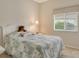 Cozy bedroom with a comfortable bed, a bedside lamp, and a window providing natural light at 9411 Forest Hills Cir, Sarasota, FL 34238