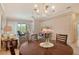 Cozy dining area with a round table, chandelier, and a view into the living space at 9411 Forest Hills Cir, Sarasota, FL 34238