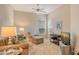 Inviting living room with cozy seating, a ceiling fan, and natural light from large windows at 9411 Forest Hills Cir, Sarasota, FL 34238
