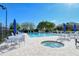 Resort-style pool area with lounge chairs, tables, umbrellas, and a relaxing jacuzzi at 9411 Forest Hills Cir, Sarasota, FL 34238