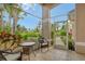 Inviting screened-in patio with tile flooring, wicker furniture and pleasant outdoor views at 9411 Forest Hills Cir, Sarasota, FL 34238