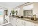 Bright bathroom with double sinks, granite counters, white cabinets, and decorative mirror lighting at 988 Blvd Of The Arts # 1209, Sarasota, FL 34236