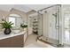 Elegant bathroom featuring a frameless glass shower, stylish vanity, and decorative shelving at 988 Blvd Of The Arts # 1209, Sarasota, FL 34236