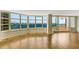 Bright living room showcasing wood floors, floor-to-ceiling windows, and a private balcony at 988 Blvd Of The Arts # 1209, Sarasota, FL 34236