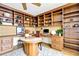 Inviting home office with custom built-in shelving, hardwood floors, and a round table at 988 Blvd Of The Arts # 1209, Sarasota, FL 34236