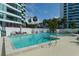 A refreshing community pool featuring clear blue water with nearby high-rise condos and lush landscaping at 988 Blvd Of The Arts # 1209, Sarasota, FL 34236