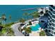 Gorgeous waterfront pool surrounded by palm trees and lush tropical landscaping at 988 Blvd Of The Arts # 1209, Sarasota, FL 34236
