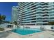 A stunning community pool featuring clear blue water with nearby high-rise condos and lush landscaping at 988 Blvd Of The Arts # 1209, Sarasota, FL 34236