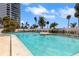 A stunning community pool featuring clear blue water with nearby high-rise condos and lush landscaping at 988 Blvd Of The Arts # 1209, Sarasota, FL 34236