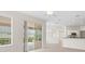 Bright living room featuring tile floor, sliding doors, and access to kitchen at 11019 Water Lily Way, Lakewood Ranch, FL 34202
