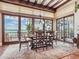 Elegant dining room with views of the water, wood beams, large windows and a decorative chandelier at 1216 N Casey Key Rd, Osprey, FL 34229