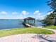 Dock with covered seating and boat lift offering direct access to the tranquil waters of the bay at 1216 N Casey Key Rd, Osprey, FL 34229