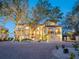 Elegant two-story home featuring mature trees, a circular driveway, and a well-manicured lawn with lush landscaping at 1216 N Casey Key Rd, Osprey, FL 34229
