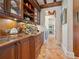 Hallway featuring terracotta tile flooring, wood cabinets with display shelving and marble countertops at 1216 N Casey Key Rd, Osprey, FL 34229
