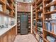 Spacious pantry with custom wood shelving, carved details and a wine fridge for optimal storage at 1216 N Casey Key Rd, Osprey, FL 34229