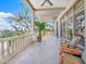 Spacious patio with columns, railings, ceiling fan, and beautiful views of the sky and nearby trees at 1216 N Casey Key Rd, Osprey, FL 34229