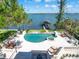 Aerial view of a luxurious pool, hot tub, and dock overlooking the water at 1216 N Casey Key Rd, Osprey, FL 34229
