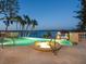 Luxurious pool and spa area with waterfront views, palm trees, and a covered dock at 1216 N Casey Key Rd, Osprey, FL 34229