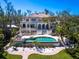 Beautiful outdoor living area with a large pool, patio, and lush landscaping, perfect for entertaining and relaxation at 1216 N Casey Key Rd, Osprey, FL 34229
