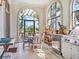 Bright sunroom with tiled floors, outdoor grill, seating, and views of surrounding landscape at 1216 N Casey Key Rd, Osprey, FL 34229