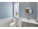 Charming powder room with beadboard, a decorative mirror, and soft blue walls at 1355 Debrecen Rd, Sarasota, FL 34240