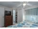 Relaxing bedroom with a ceiling fan, storage dresser, and a view into the bathroom at 1416 41St E Ave, Ellenton, FL 34222