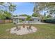 Backyard with mature trees, lawn, fire pit, and patio furniture, perfect for outdoor enjoyment at 1507 30Th W St, Bradenton, FL 34205