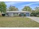 Charming one-story home boasts a well-manicured front lawn, complemented by mature landscaping and a gray metal roof at 1507 30Th W St, Bradenton, FL 34205