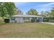 Charming one-story home boasts a well-manicured front lawn, complemented by mature landscaping and a gray metal roof at 1507 30Th W St, Bradenton, FL 34205