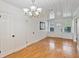 Bright living room with wood floors, white walls and trim, and a modern light fixture at 1507 30Th W St, Bradenton, FL 34205