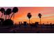 Beach scene with a colorful sunset, palm trees, parked car, and pedestrians at Siesta Key beach at 1507 30Th W St, Bradenton, FL 34205