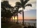 Scenic waterfront view with palm trees, park benches and the sunset over the bay and the bridge at 1507 30Th W St, Bradenton, FL 34205