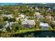 An aerial view of the house featuring a waterfront backyard, screened pool, and lush landscaping at 1575 Eastbrook Dr, Sarasota, FL 34231