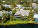 An aerial view of the house featuring a waterfront backyard, screened pool, and lush landscaping at 1575 Eastbrook Dr, Sarasota, FL 34231