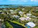 Wide aerial view of a waterfront property with a canal, surrounding homes, and skyline view in the distance at 1575 Eastbrook Dr, Sarasota, FL 34231