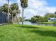 The backyard offers a serene waterfront setting surrounded by mature trees and landscaping at 1575 Eastbrook Dr, Sarasota, FL 34231